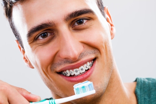 Man with braces uses toothbrush