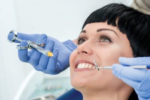 Woman sitting in a dentist chair about to get anesthesia