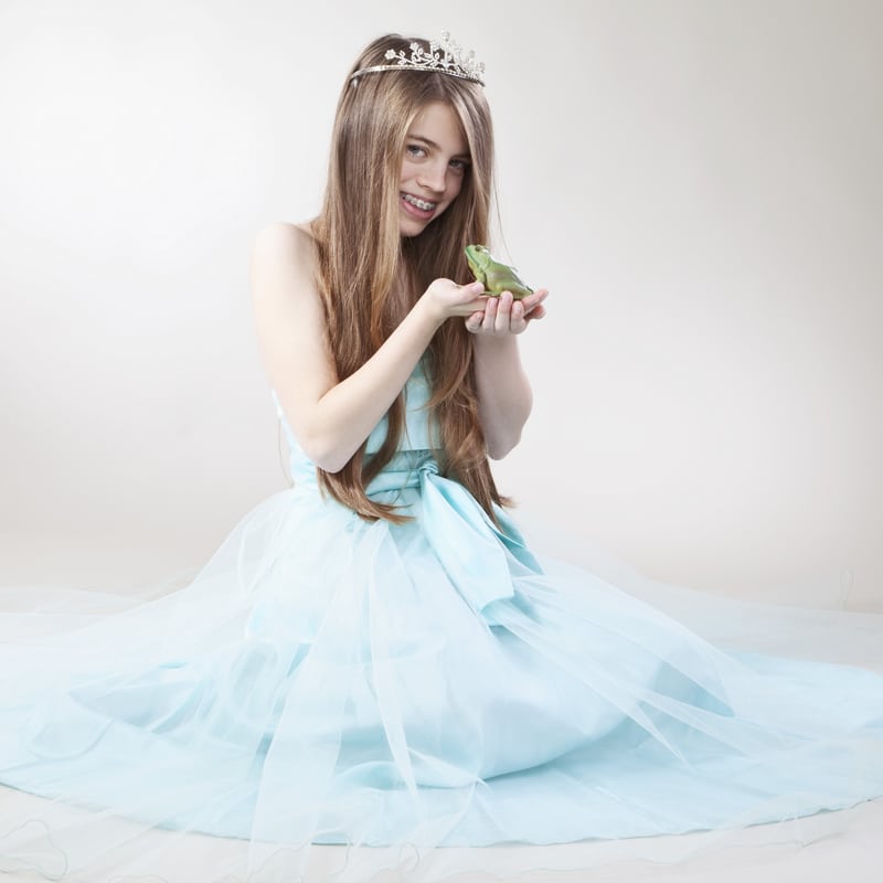 girl with braces about to kiss a frog