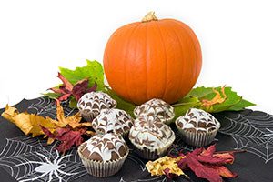 Image of six cupcakes on a table with Halloween decorations