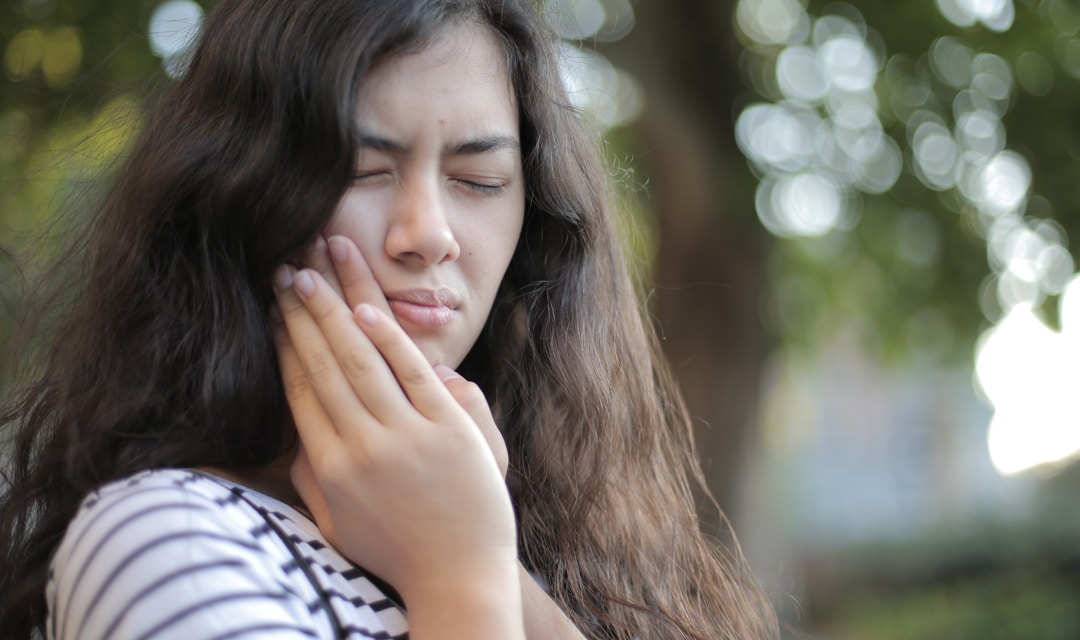 Person outside holding their jaw in pain