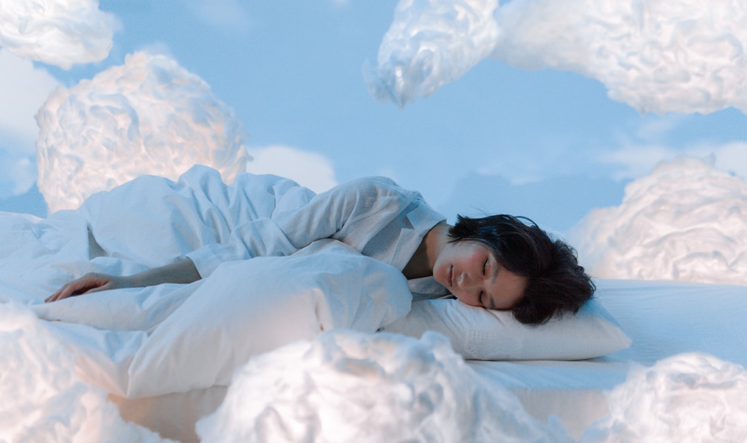 Person sleeping surrounded by clouds on a blue background